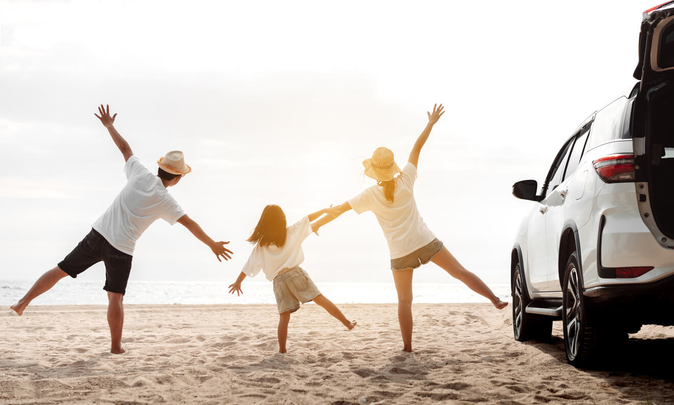 A family of three playing on the beach