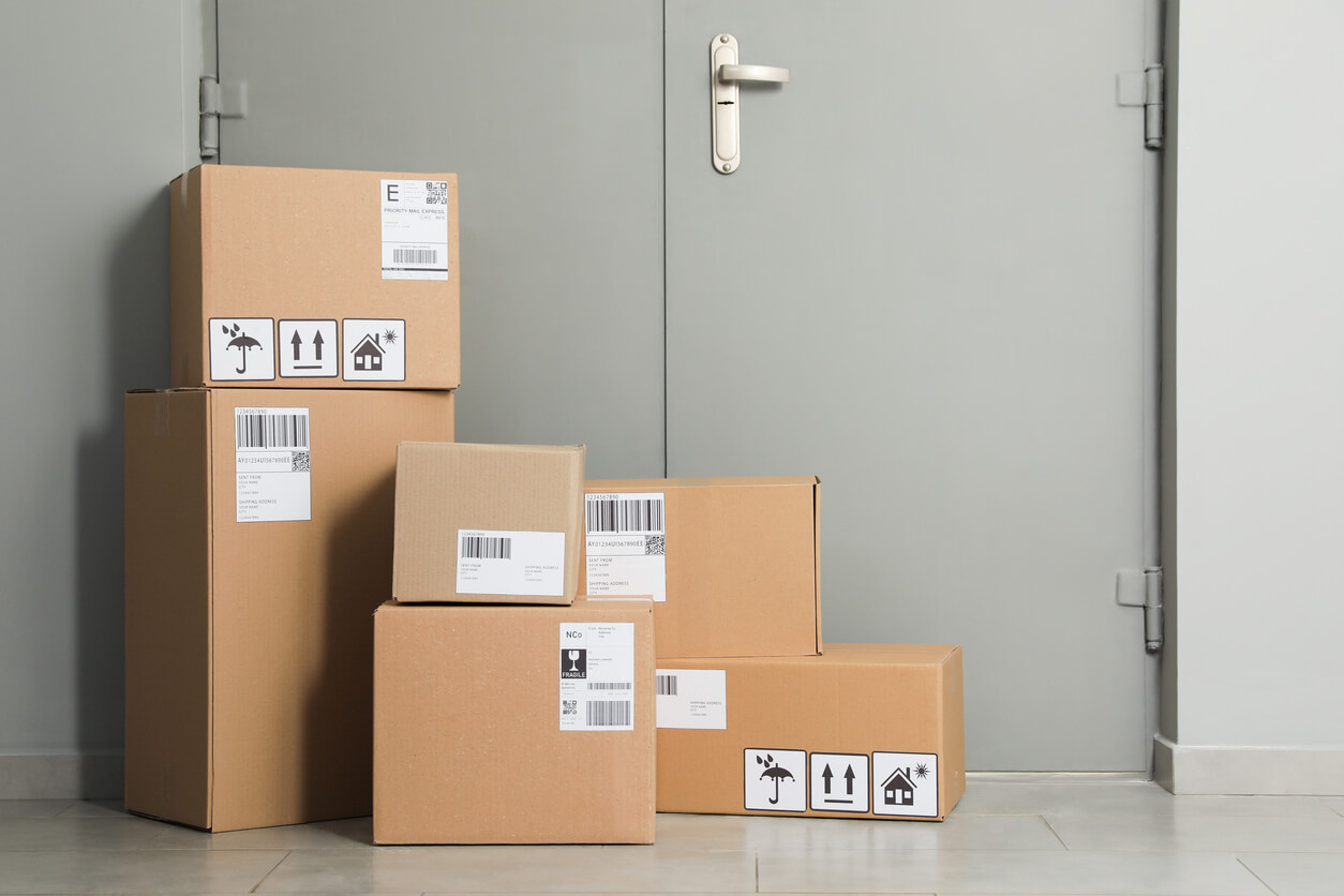 Packed boxes for storage stacked on the floor near an entrance.